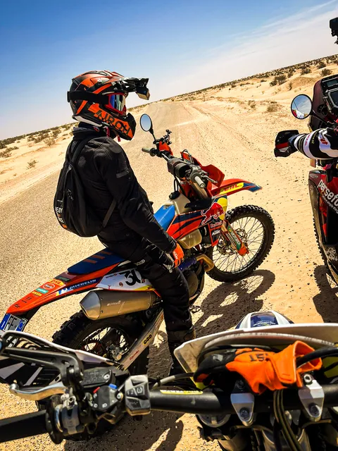 Un pilota in attesa sulla sua KTM, su una pista nel deserto